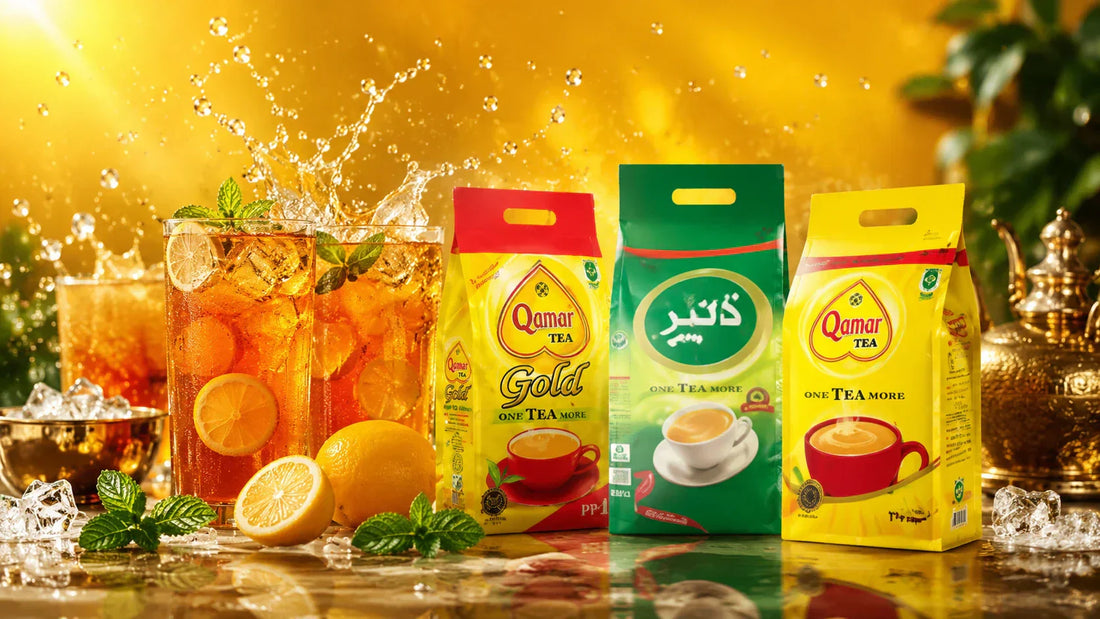 Qamar Tea Gold and green packages displayed with iced tea glasses, fresh lemon slices, mint leaves, and ice cubes.